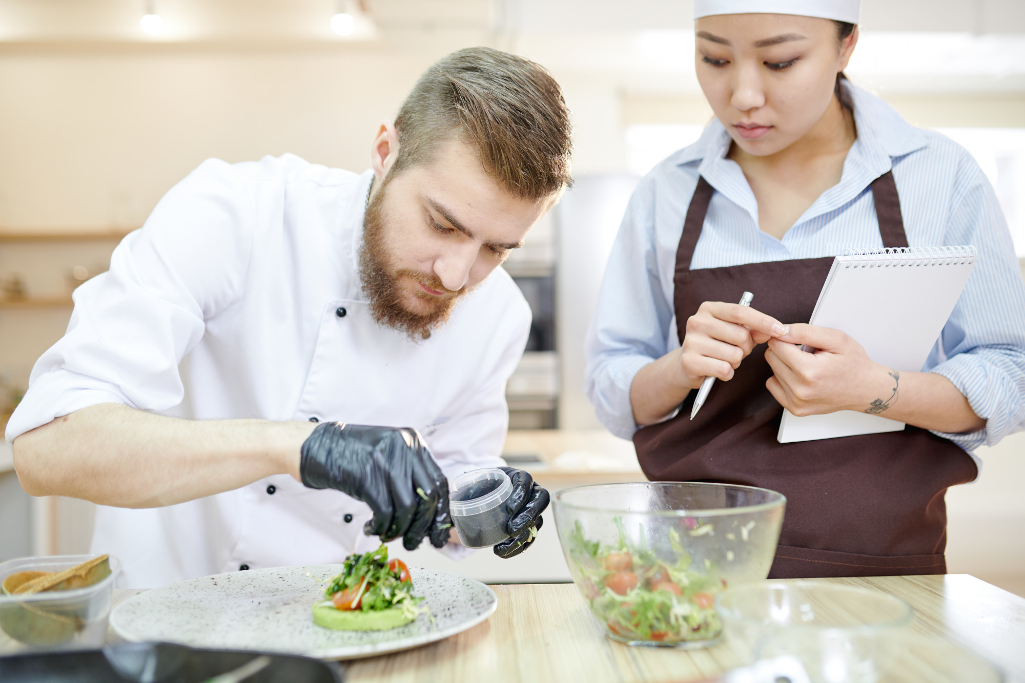 Chef working with sous-chef on plating techniques